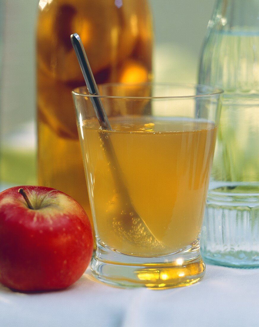 Apfelessig im Glas mit Löffel, Deko: Apfel & Flaschen
