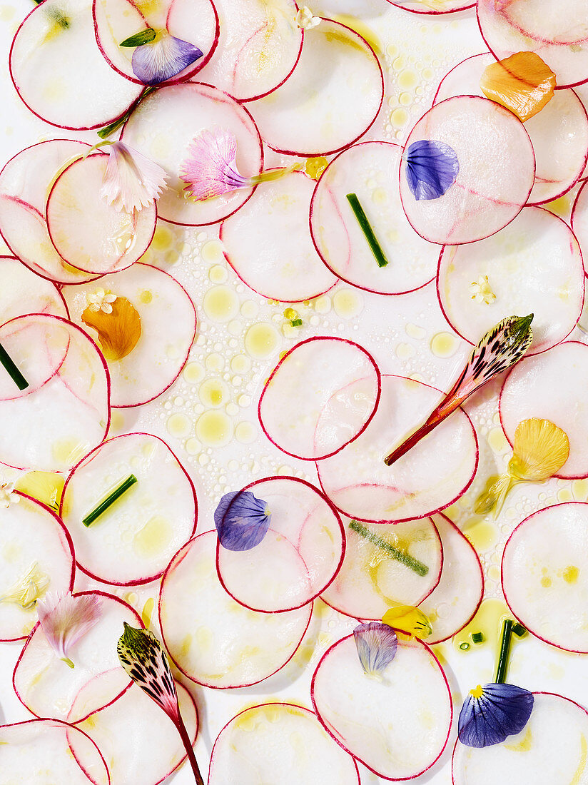 Geschnittene Radieschen mit Essblüten und Vinaigrette