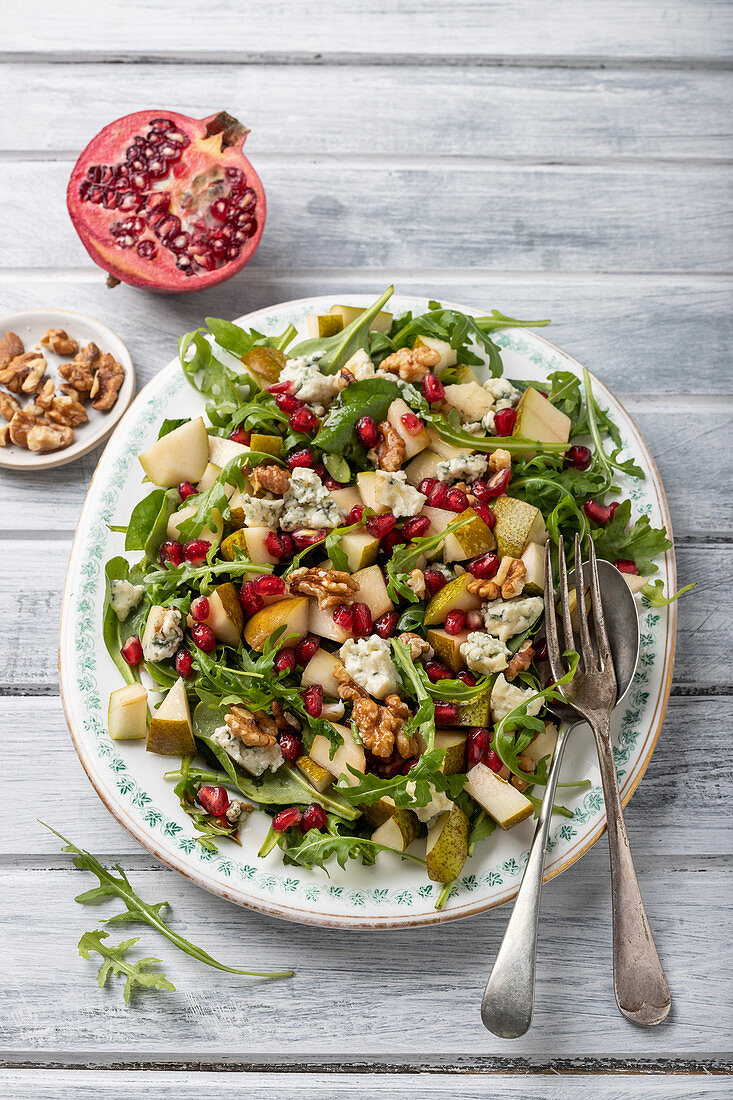 Pear, salad with gorgonzola cheese, pomagranate seeds, rocket, walnuts, walnuts and half of pomegranate