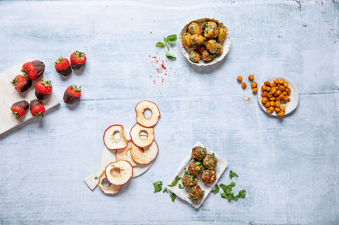 Healthy snacks: chocolate strawberries, apple rings, olives, curried chickpeas, tomato cakes