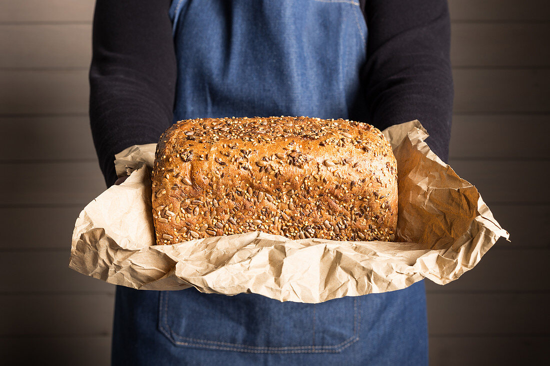 Freshly baked bread loaf with seeds on parchment