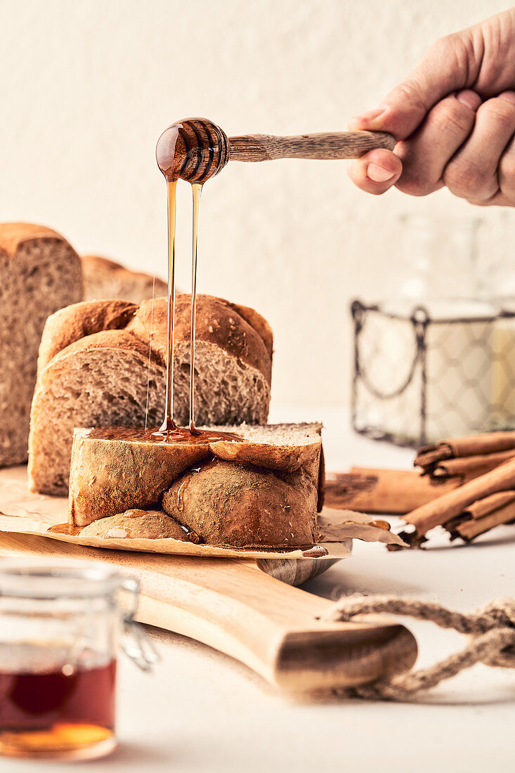 Pouring honey on fresh bread