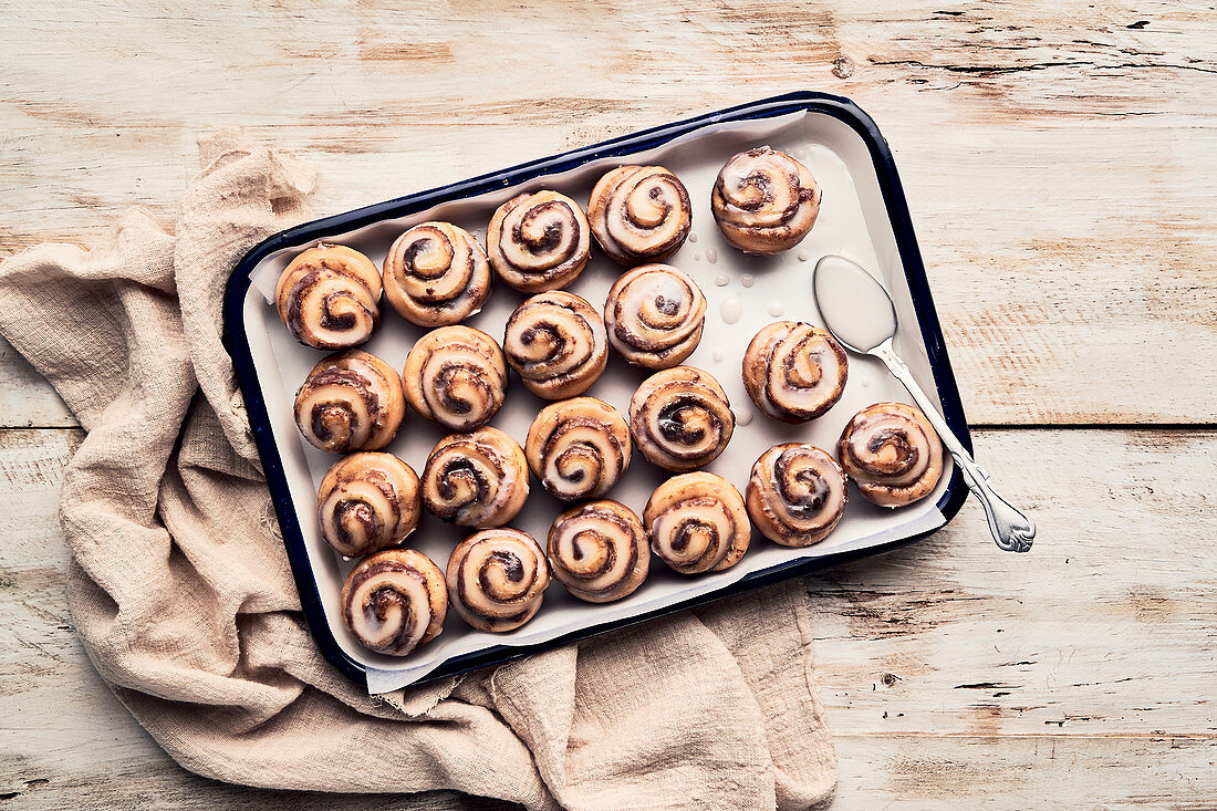 Glazed cinnamon rolls on baking tray