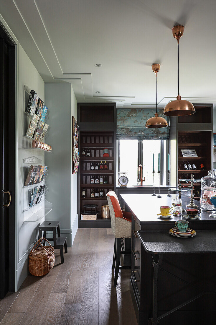 Console table and island counter in open-plan kitchen with wine racks