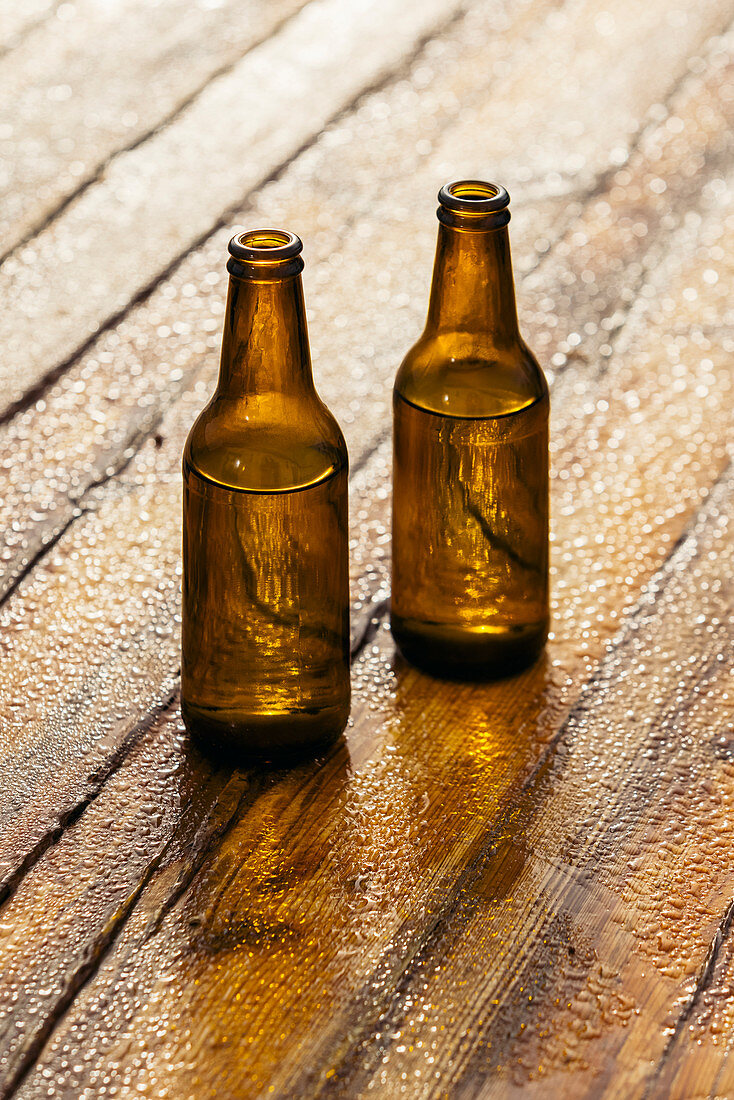Two beer bottles on wooden surface