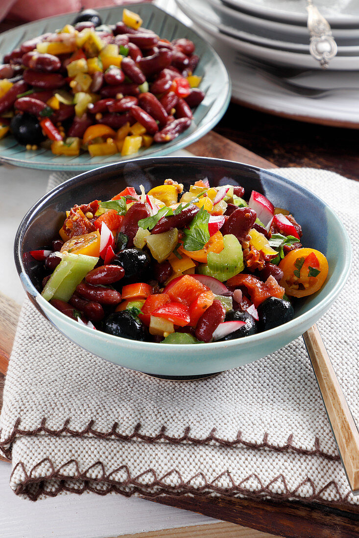 Bunter Salat mit roten Bohnen, Paprika, Oliven, Sellerie, Radieschen und Kirschen