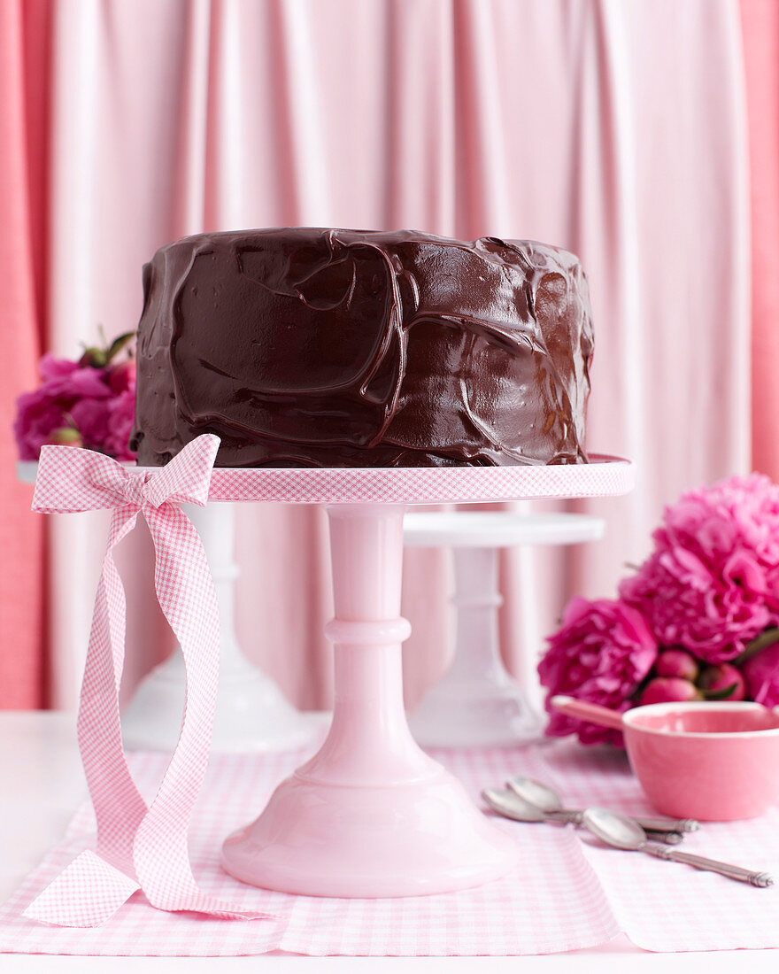 Sechsschichtige Schokoladentorte auf rosa Tortenständer