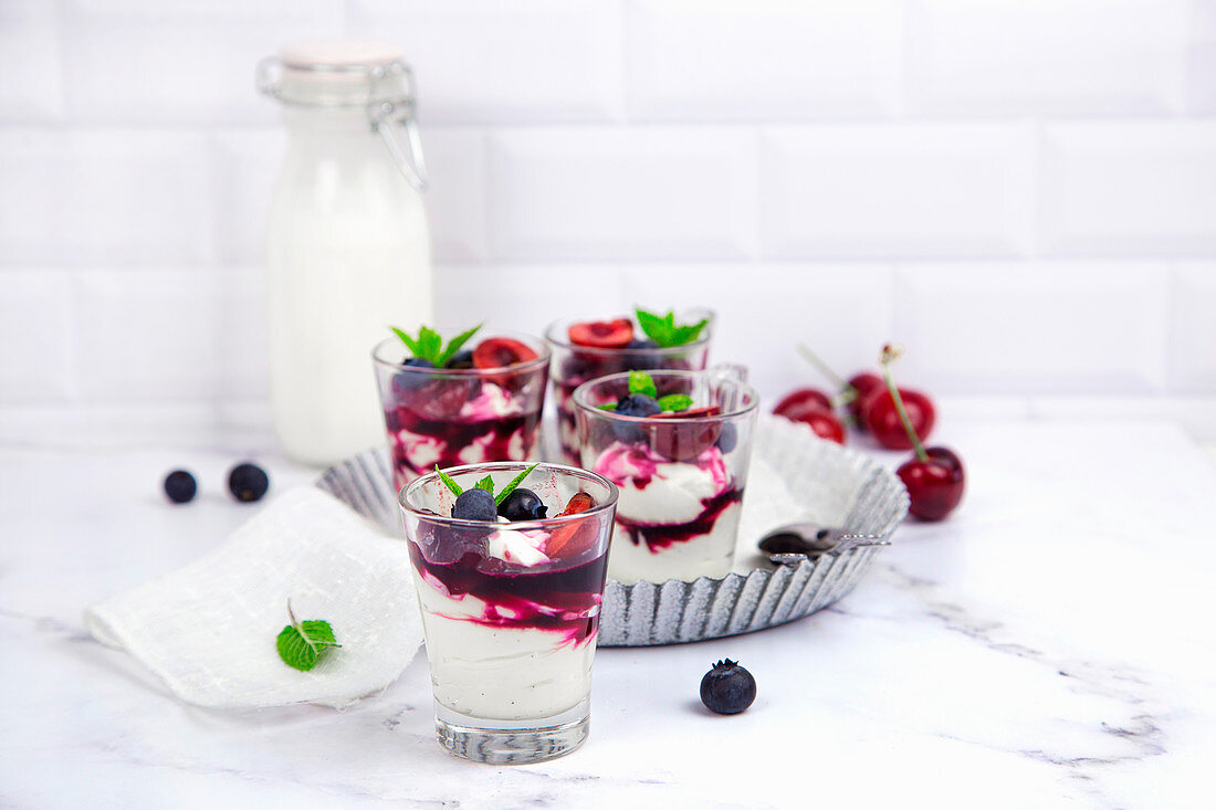 Small glasses with mascarpone cream and egg-free cream with cherries and blackberrie