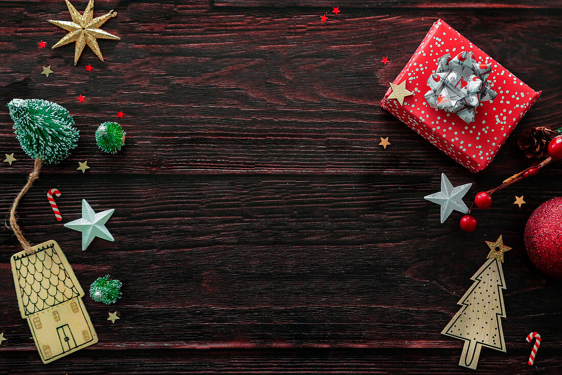 Geschenkpäckchen und Weihnachtsdekorationen auf Holzuntergrund