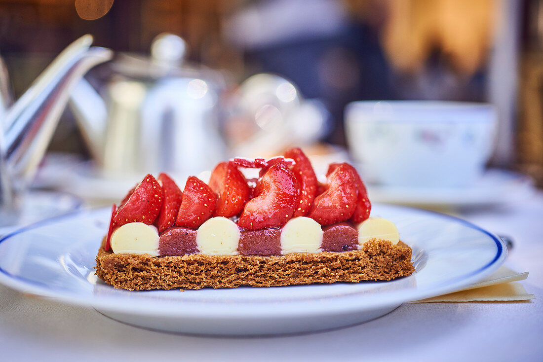 A piece of strawberry cake on a coffee table