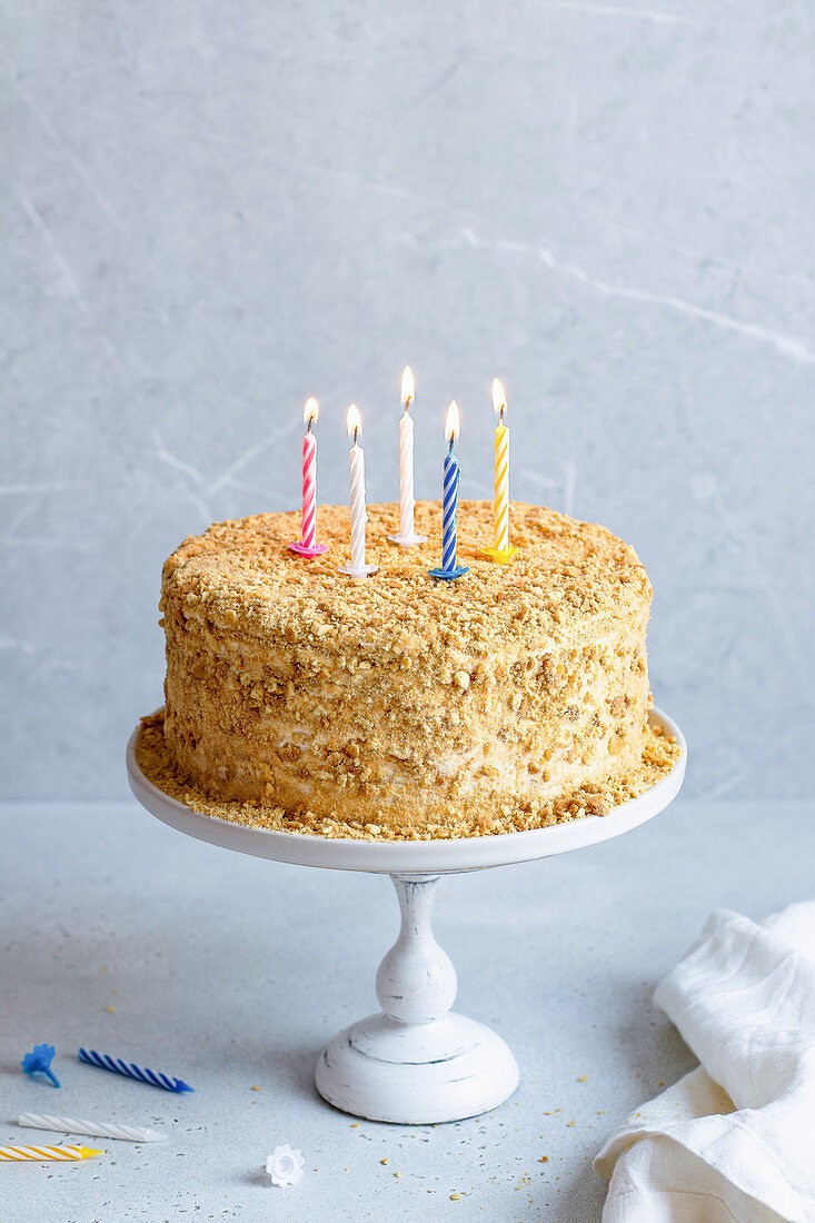 Honey cake with burning candles for birthday