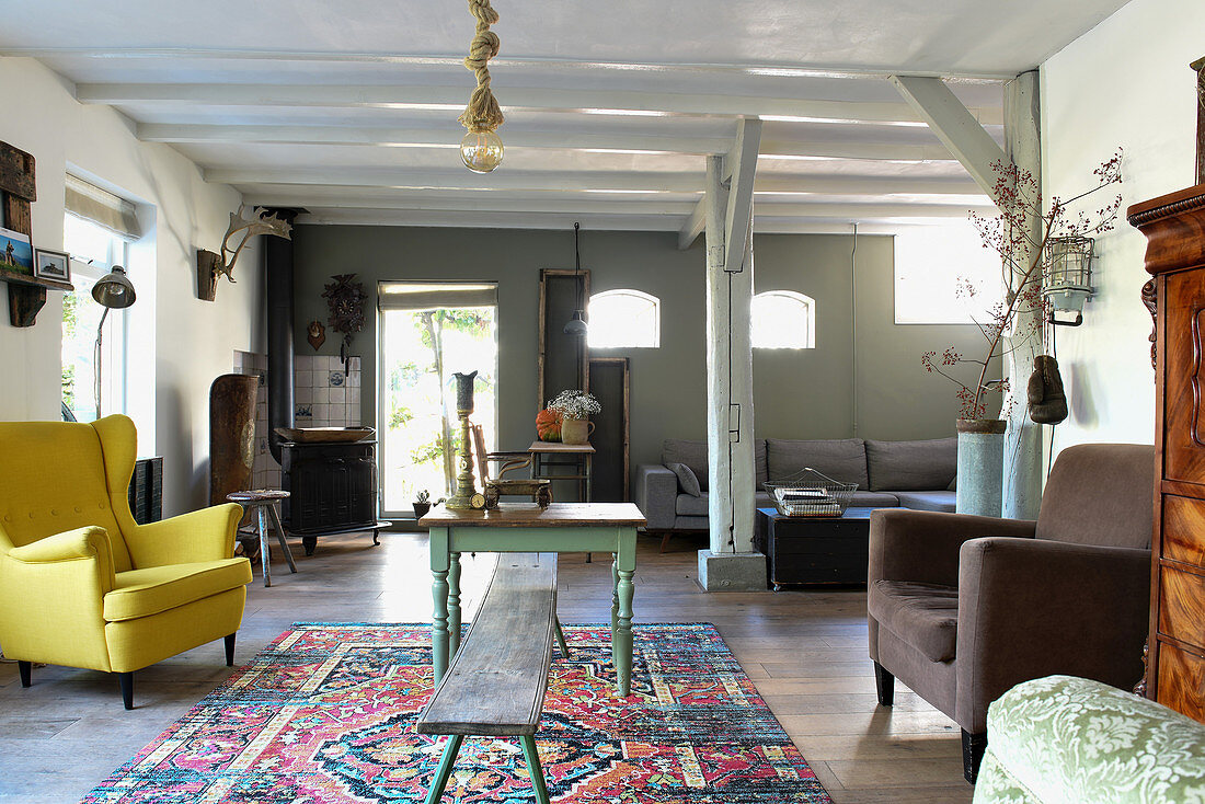 Wohnzimmer im Landhausstil mit Holzbalken und Vintagemöbeln