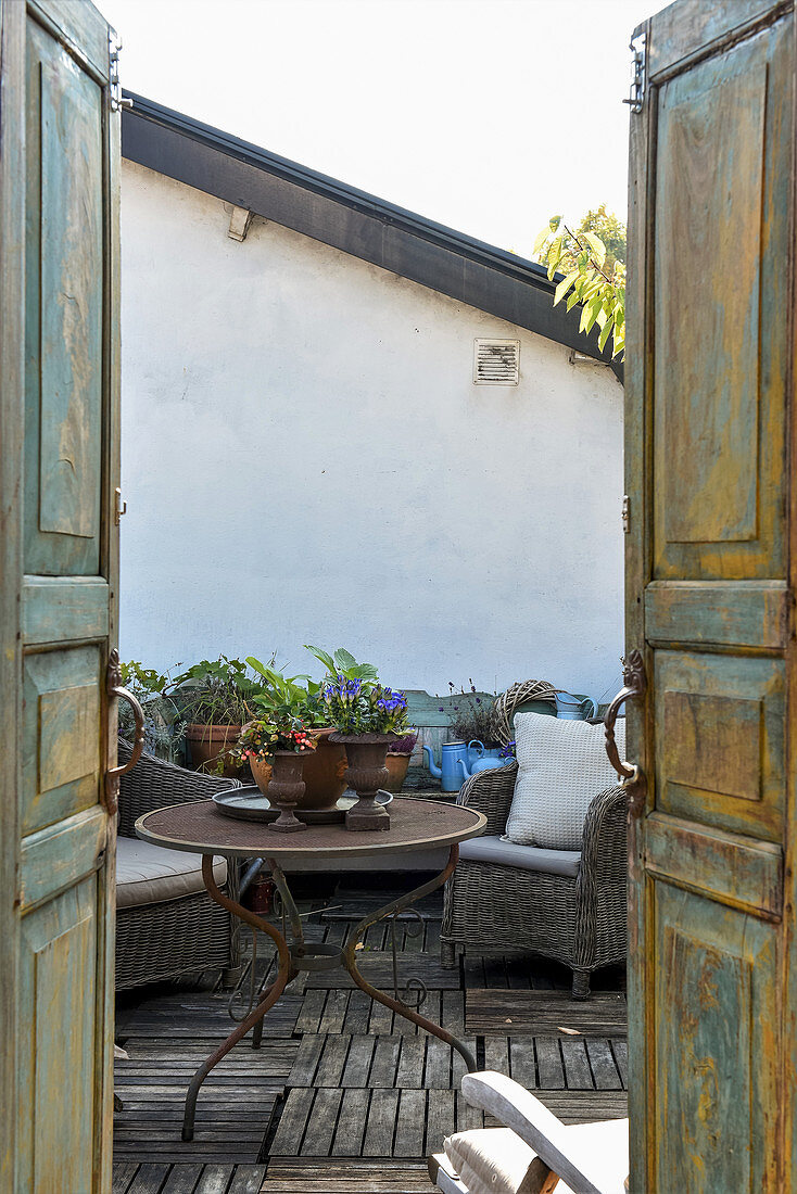 Blick durch Doppeltüren mit Patina auf die Dachterrasse im Vintagestil