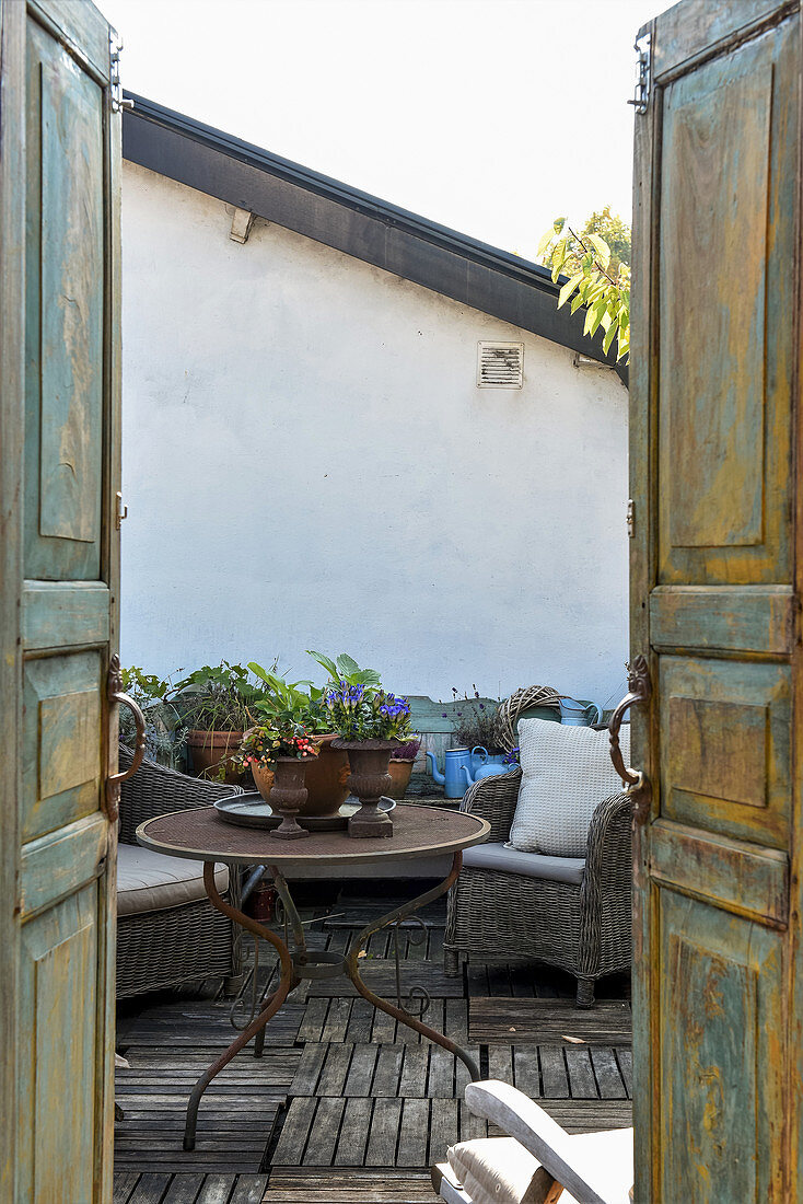 View through weathered double doors onto vintage-style roof terrace