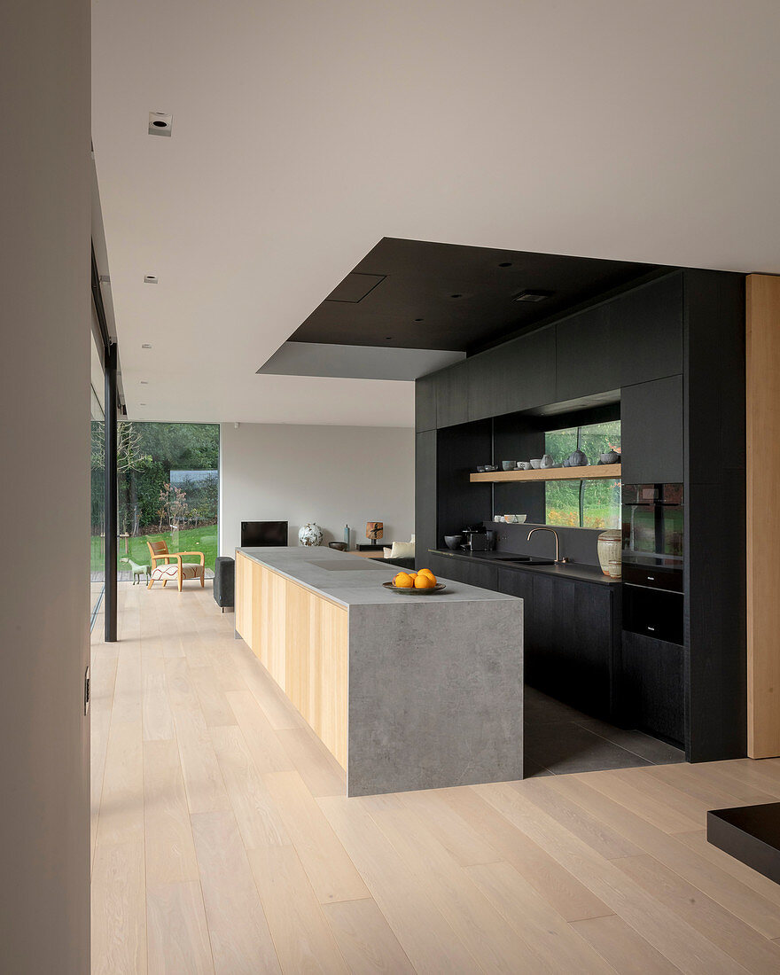 Modern kitchen in black and grey in open-plan interior