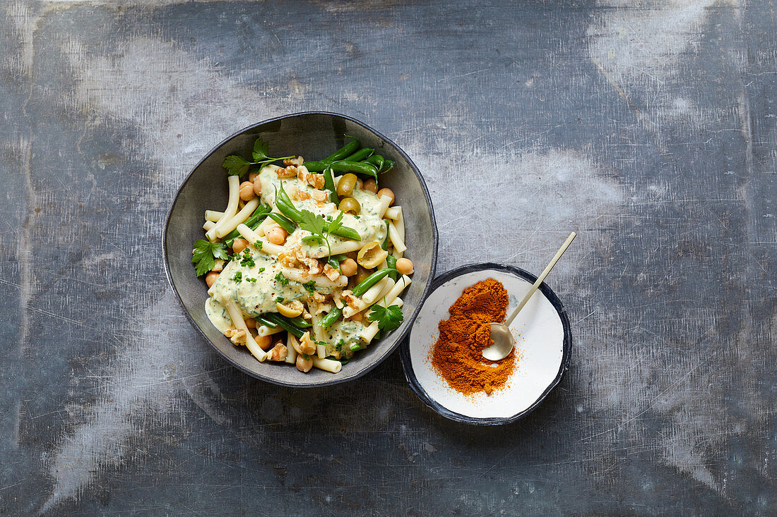 Pasta salad with chickpeas, green beans, olives and walnuts