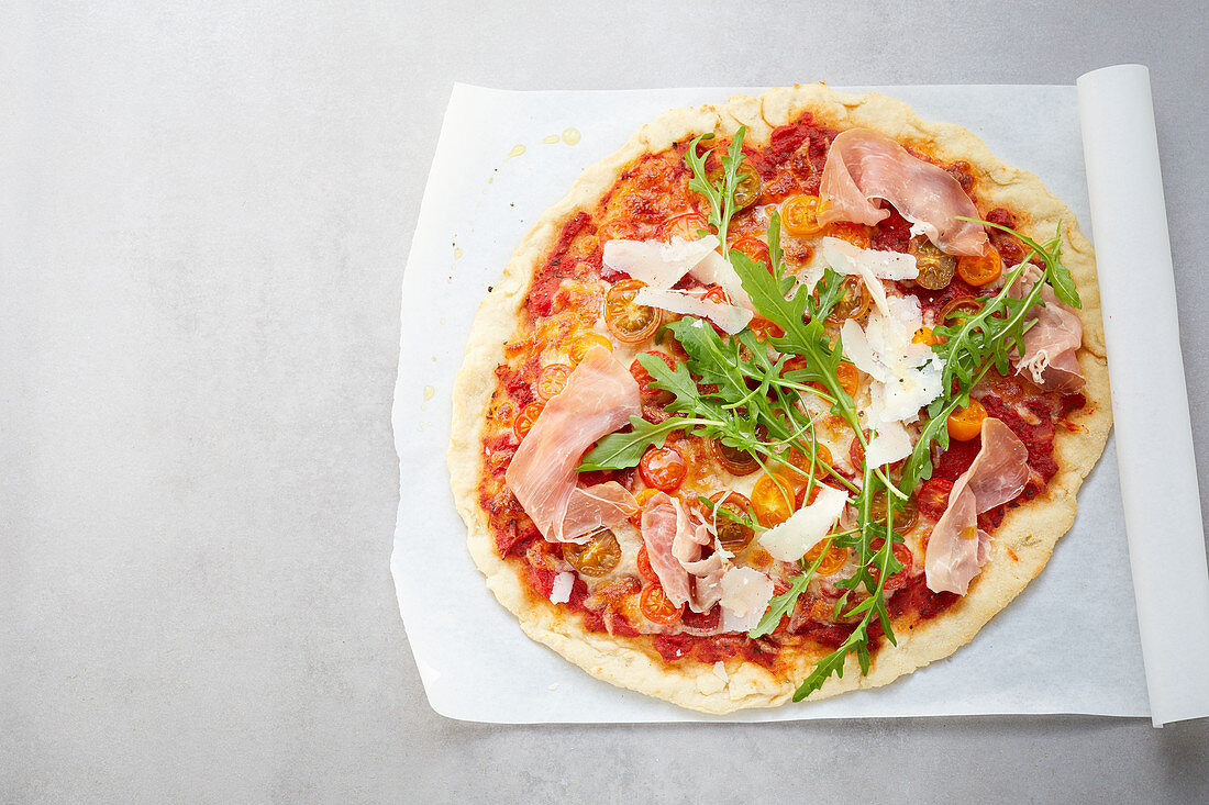 A pizza with Parma ham, rocket and Parmesan