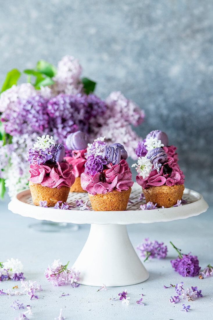 Blueberry cupcakes topped with purple macarons and lilac flowers