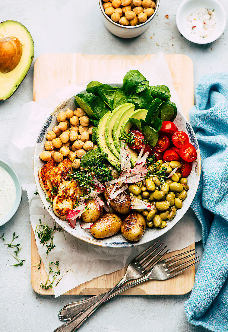 Healthy salad bowl with avocado, chickpeas, and halloumi cheese