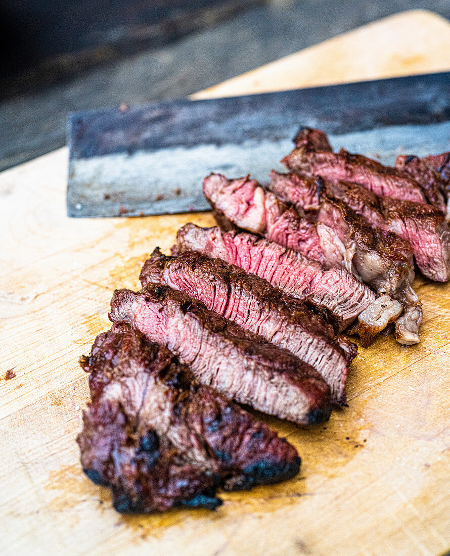 Cutting a grilled beef steak into strips