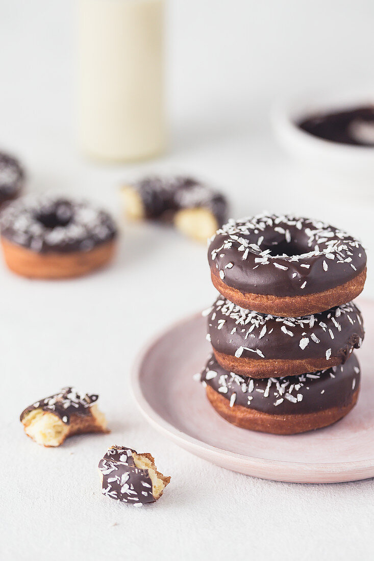 Stack of a donuts with chocolate glaze and coconut shreds