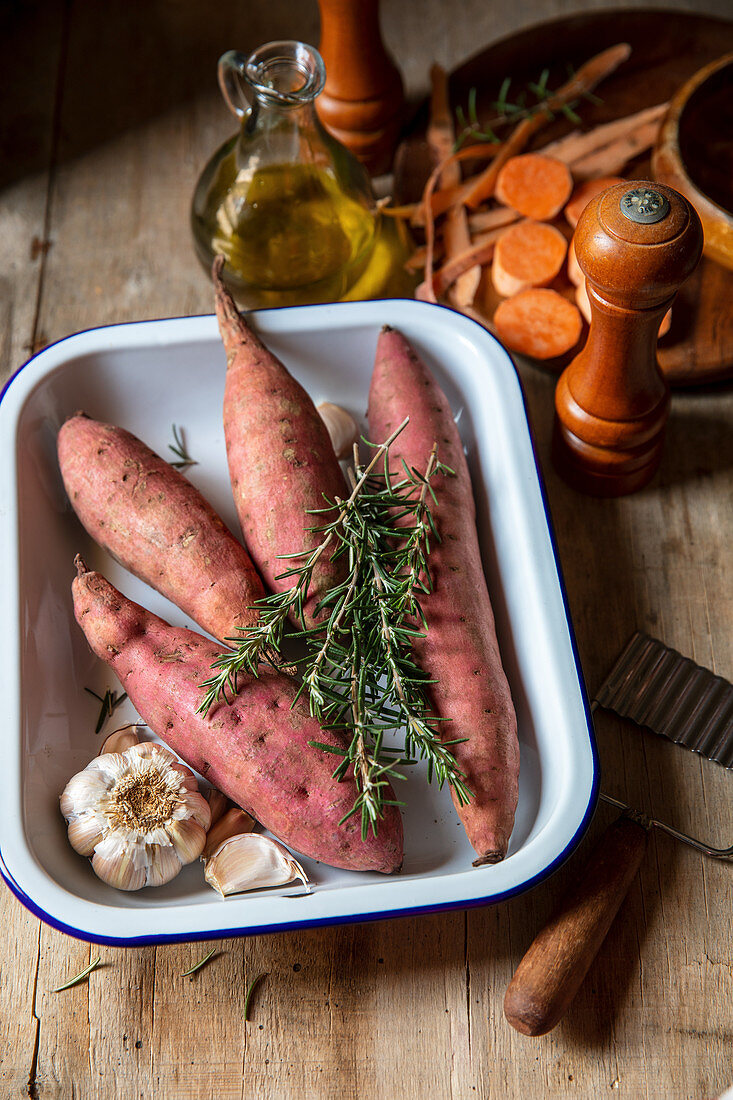 Ingredients for making roasted sweet potatoes with garlic, rosemary and olive oil