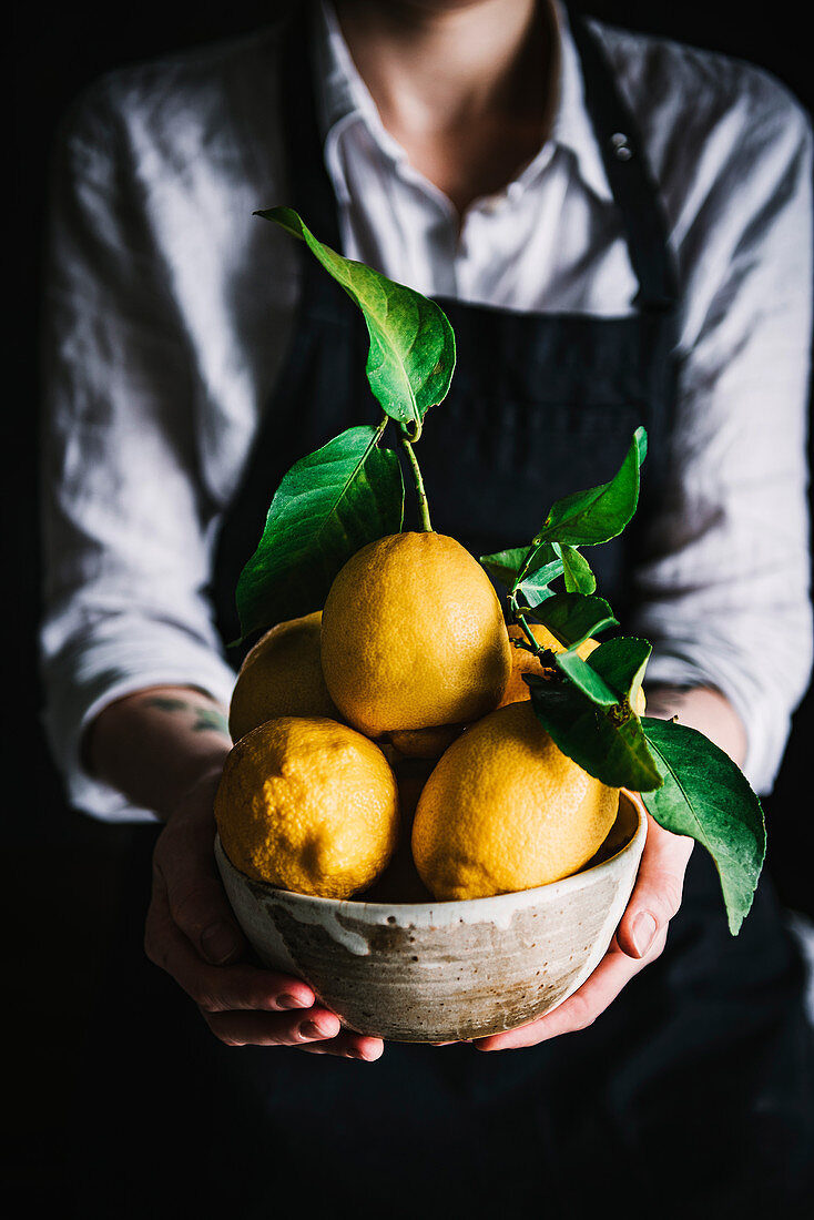 Woman Holding Bowl with Lemons
