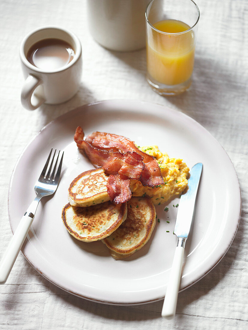 Potato pancakes with scrambled eggs and crispy bacon