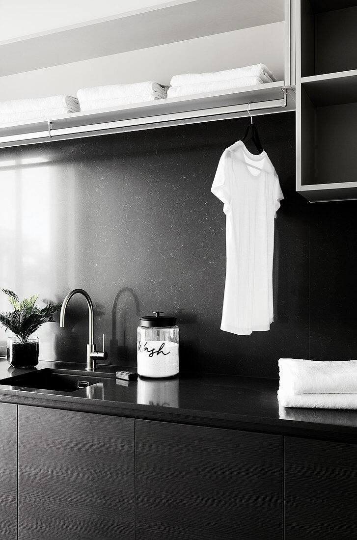 Moderne Waschküche in Schwarz und Grau mit Kleiderstange