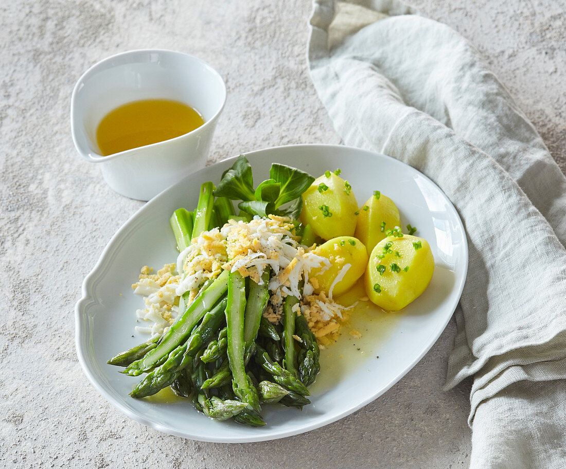 Grüner Spargel mit Butter und gekochtem Ei dazu Salzkartoffeln