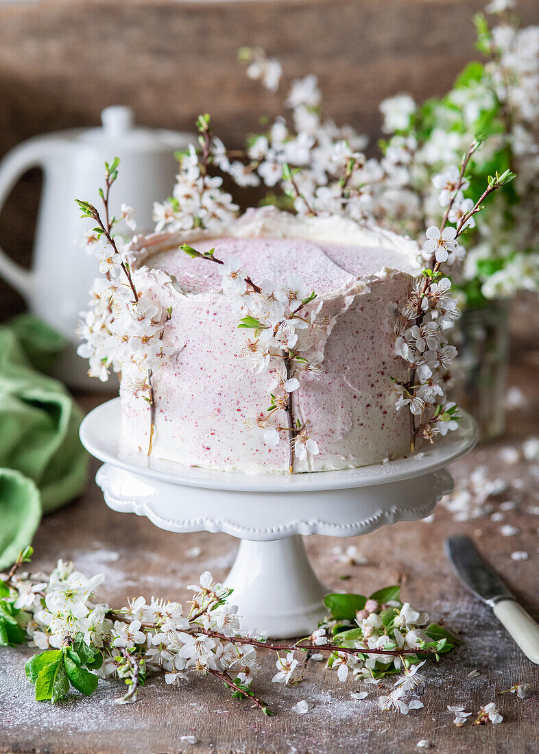 A buttercream cake with dried raspberries and spring flowers