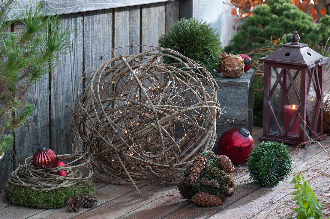 Ball of clematis vines with fairy lights, Christmas tree ornaments, moss wreath, and lantern