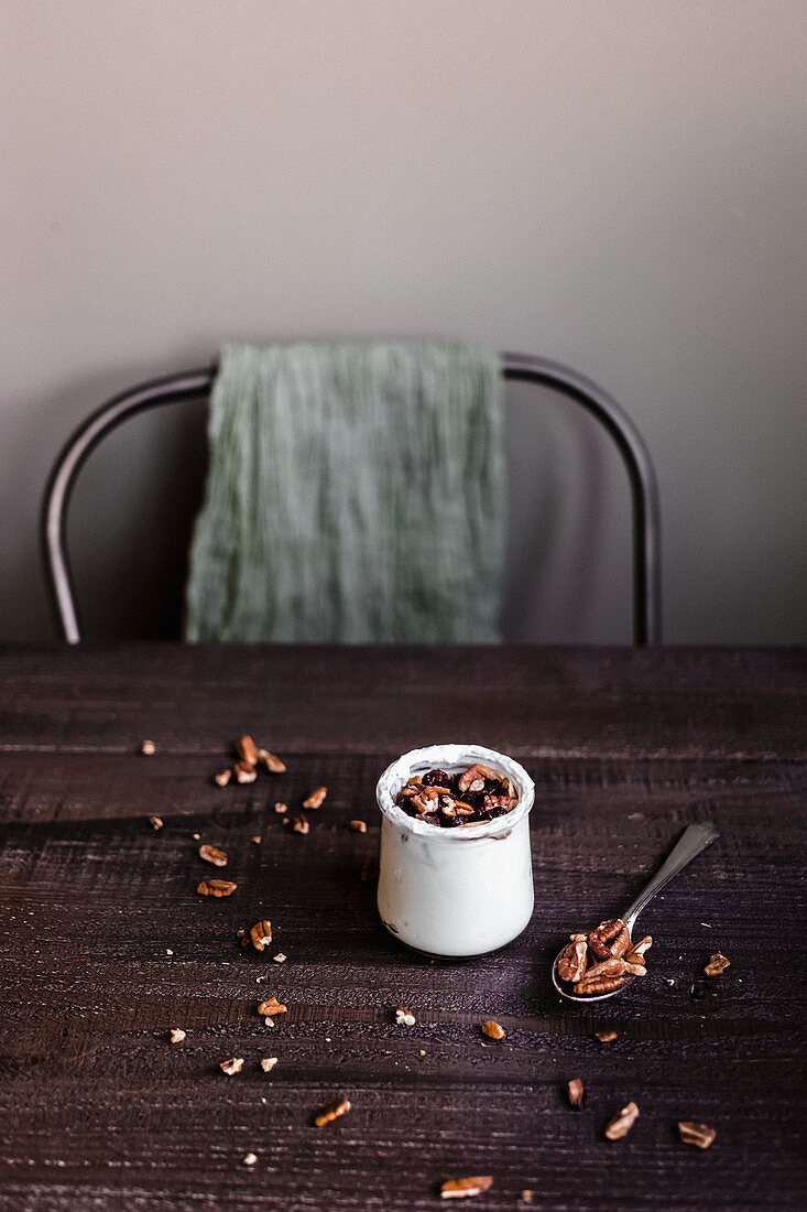 Joghurt mit Pekannüssen auf rustikalem Holztisch