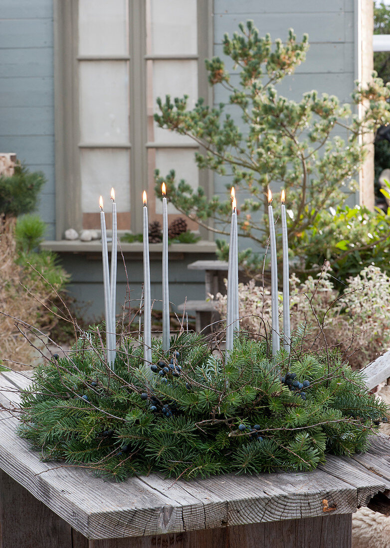 Advent wreath made of fir branches and sloe with berries, silver candles