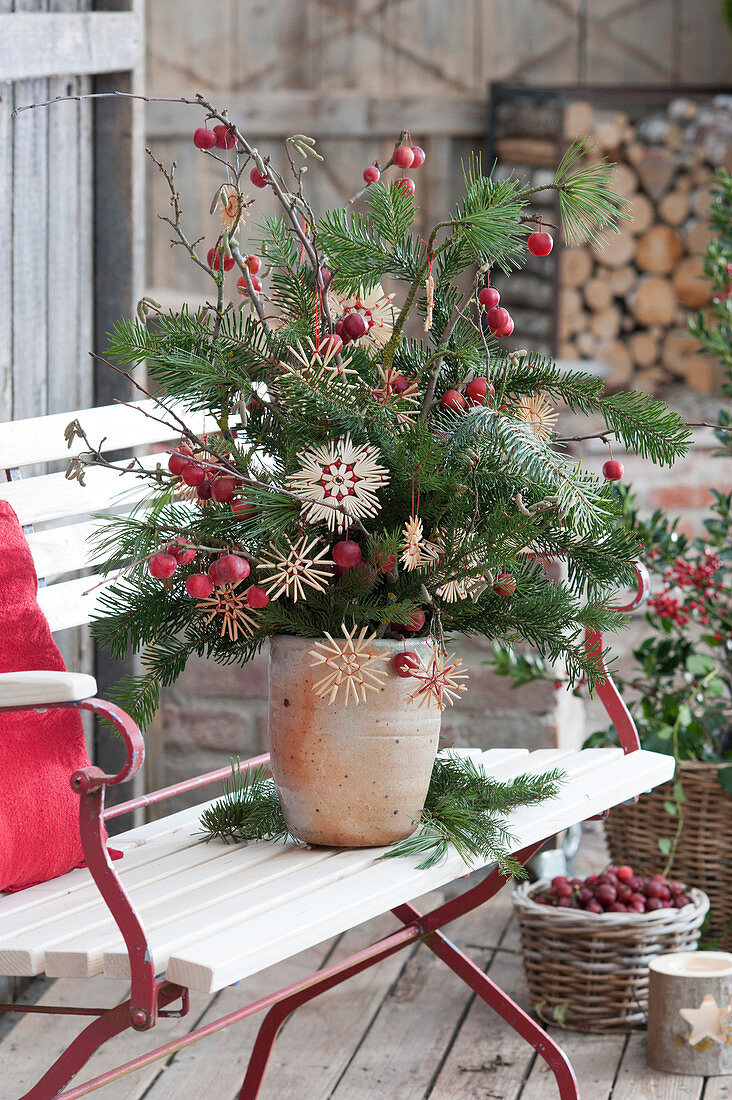 Weihnachtsstrauß aus Zweigen von Nordmanntanne, Kiefer, und Zierapfel, mit Strohsternen geschmückt