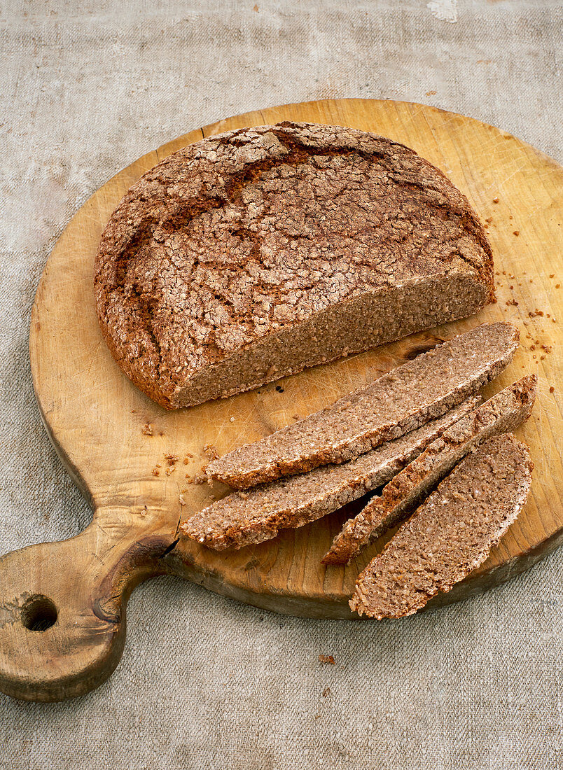 Klassisches Sauerteigbrot, angeschnitten auf Holzbrett