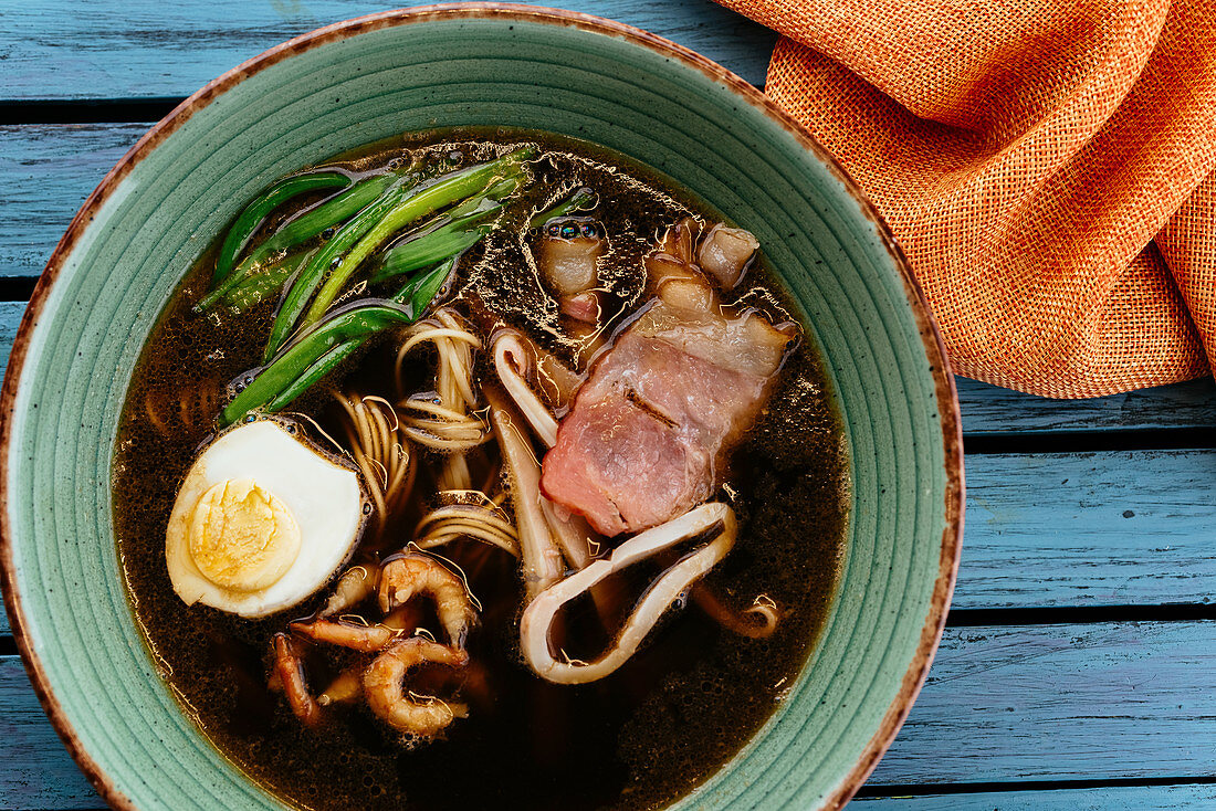 Asian noodle soup with egg and seafood