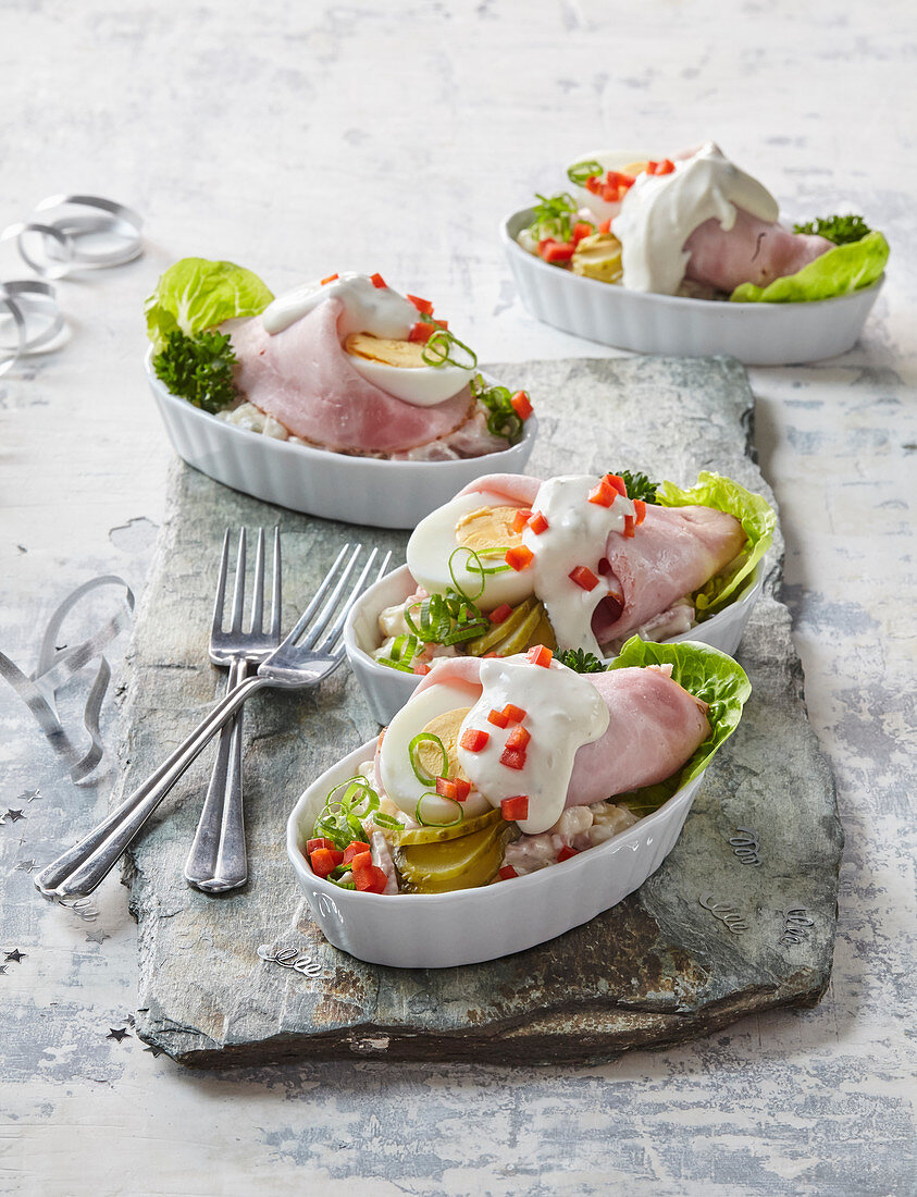 Schinkenröllchen und gekochte Eier auf  Kartoffel-Wurst-Salat