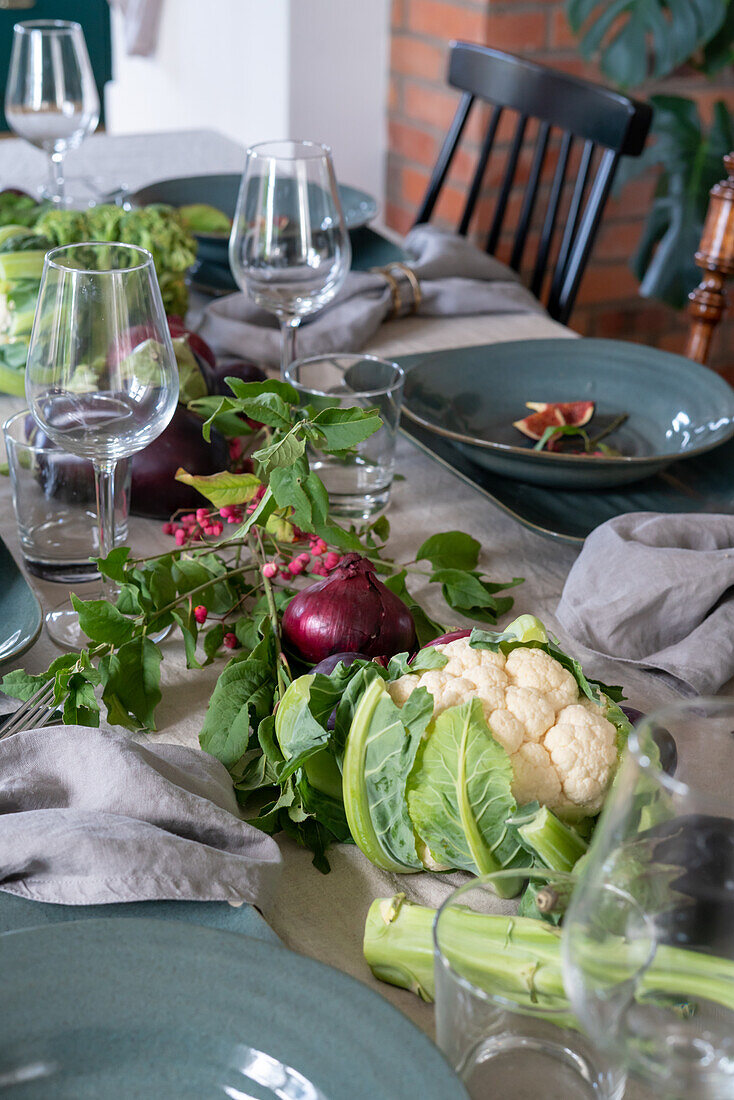 Set table with centrepiece of vegetables for harvest festival