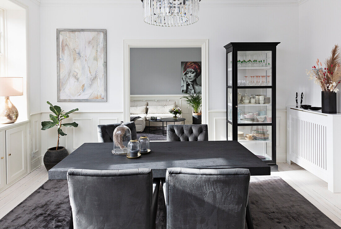 Dining table with passage to the grey and white living room in an old building