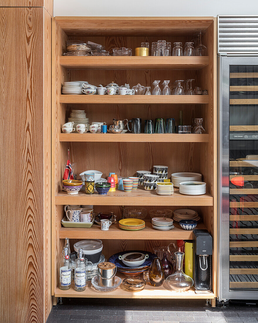 Open shelving in kitchen full of crockery and glassware