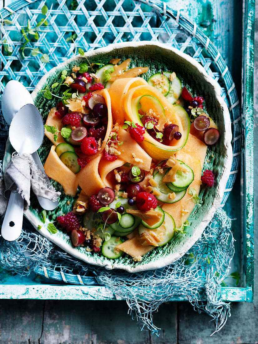 Cantaloupemelonensalat mit Gurke, Trauben, Himbeeren und Melonenkern-Krokant