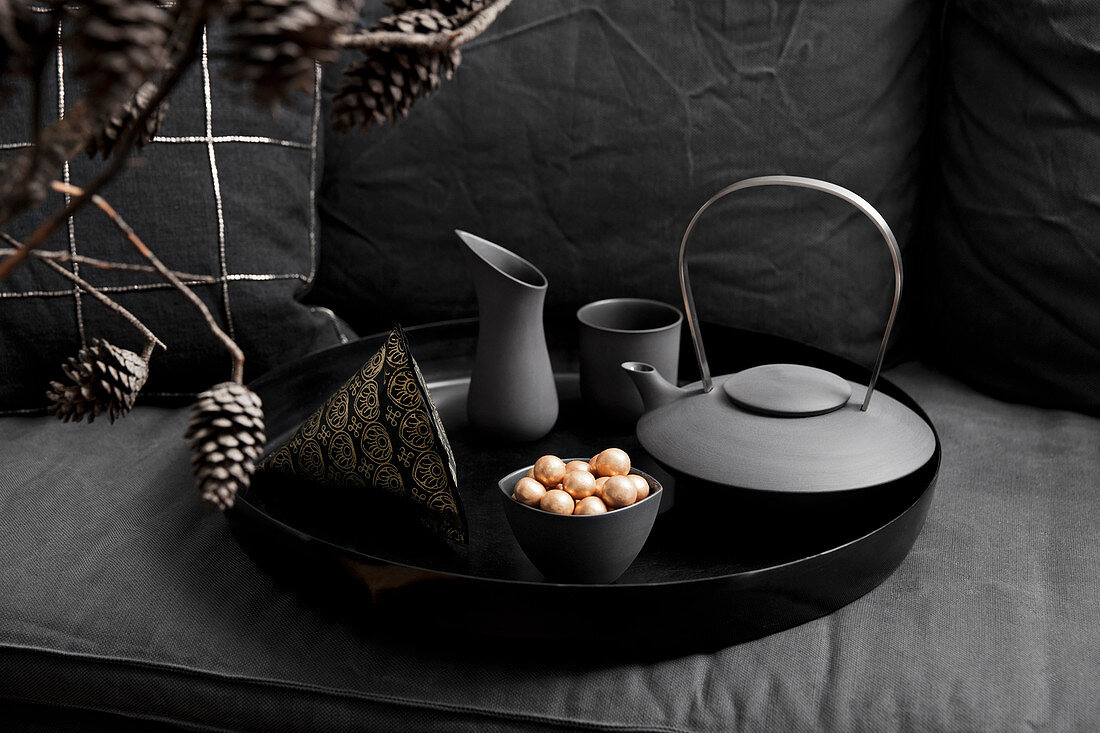 Teapot and containers on black tray