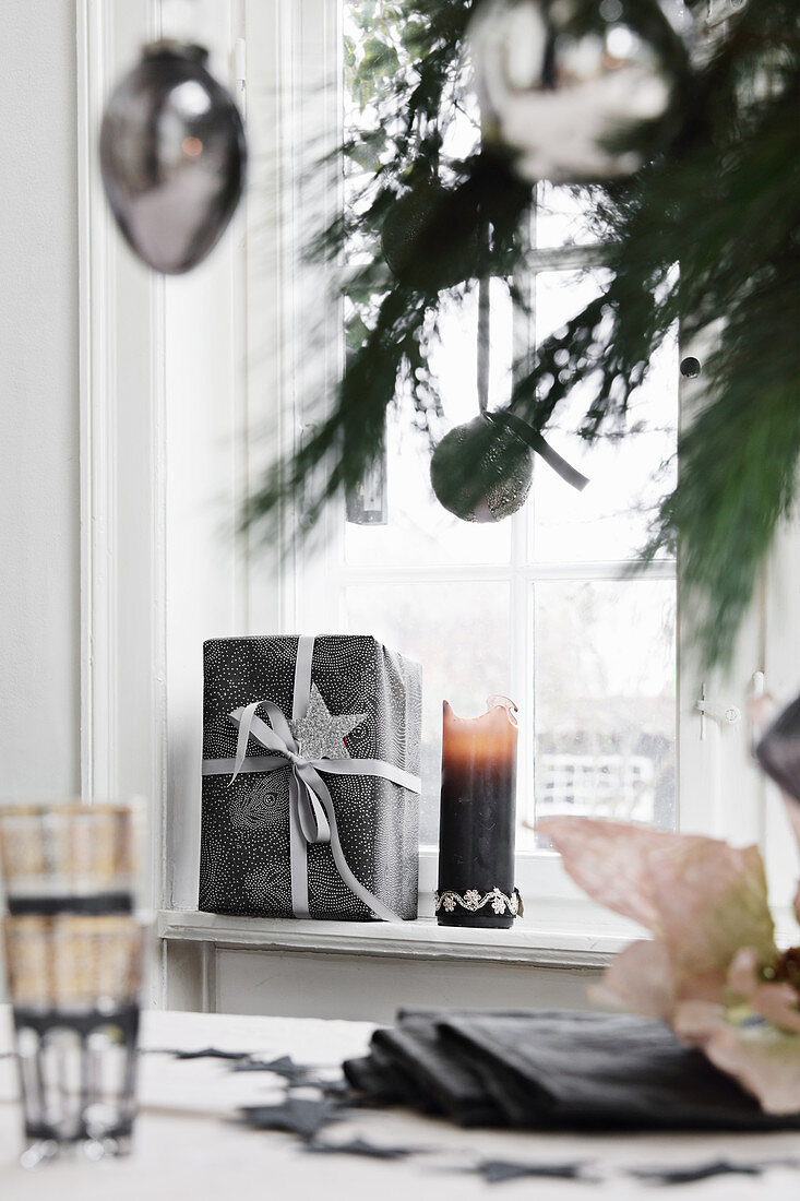 Gifts and candle on windowsill