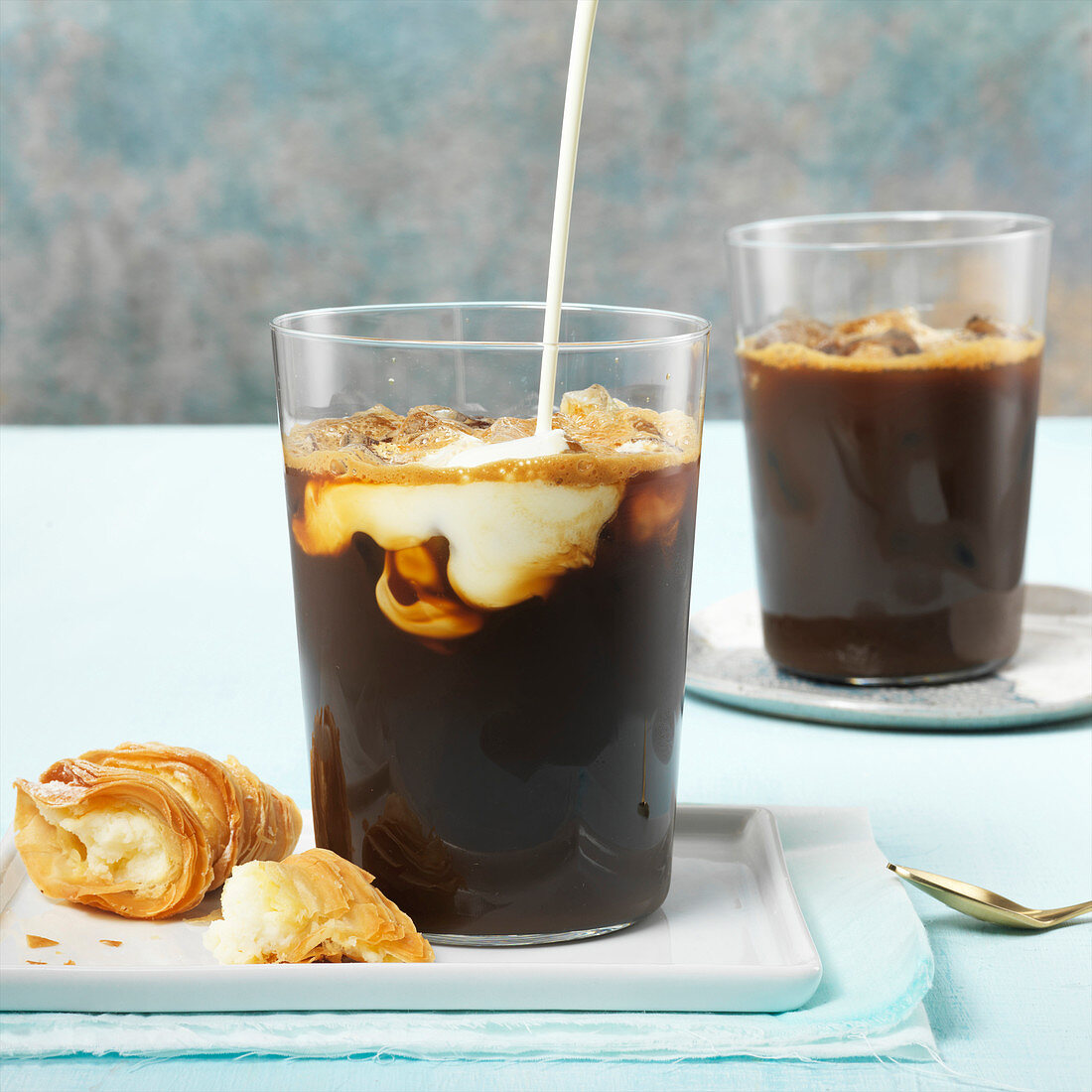 Iced Coffees With Milk Pour And A Cannoli Pastry