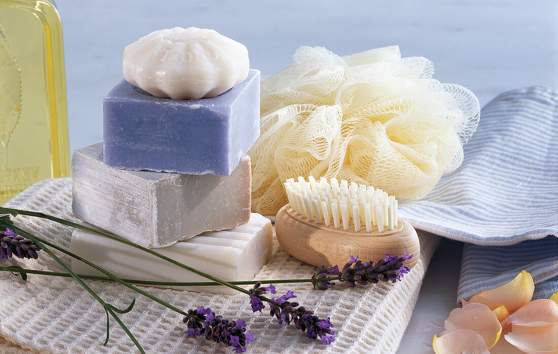 Wellness-Stilleben mit Seifen, Bürste, Lavendel und Rosenblättern