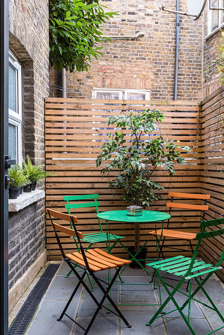 Seat on small terrace with privacy screen in an inner courtyard