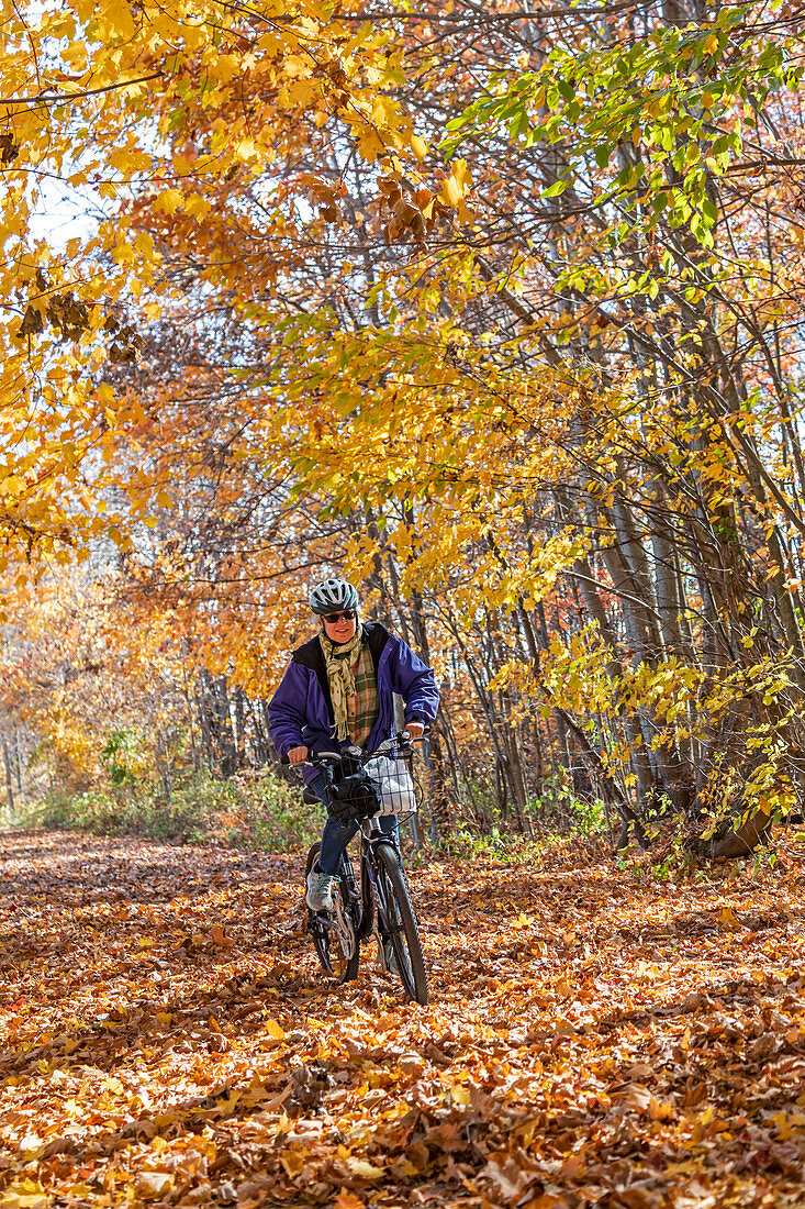 Woman riding a bicycle on a trail, Michigan, USA
