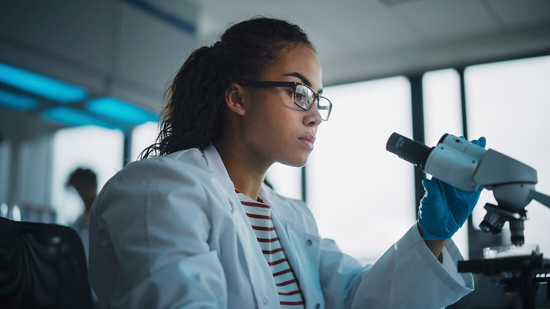 Scientist using microscope in laboratory