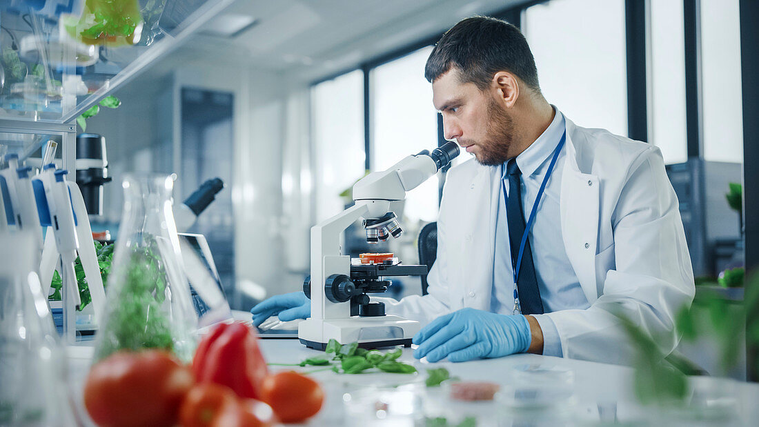 Scientist in safety glasses analyzing a lab-grown food